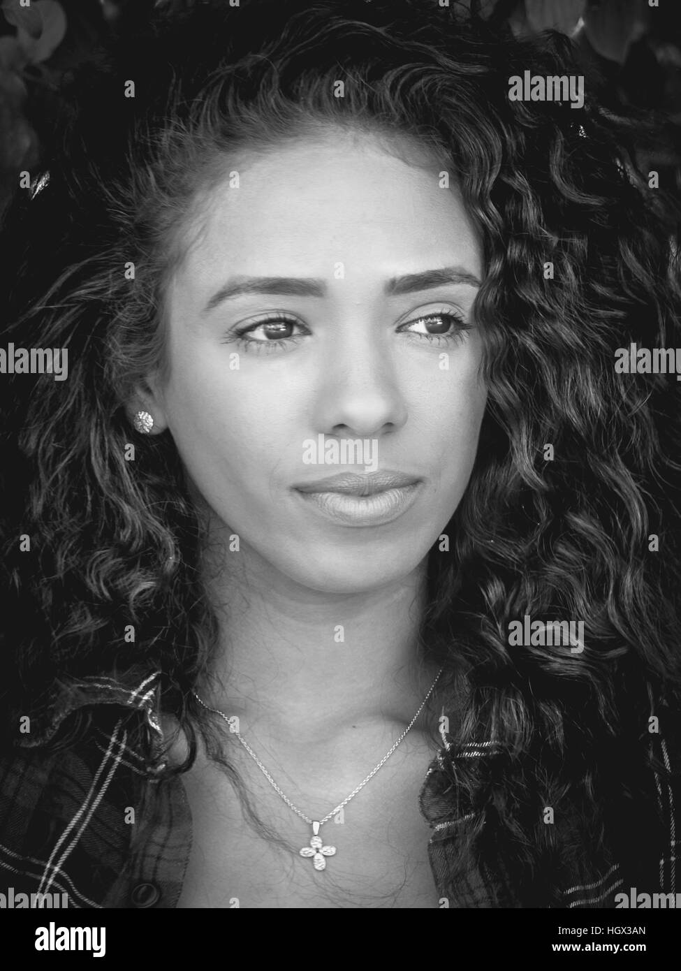 Portrait de femme latine avec des cheveux bouclés regardant à droite Banque D'Images