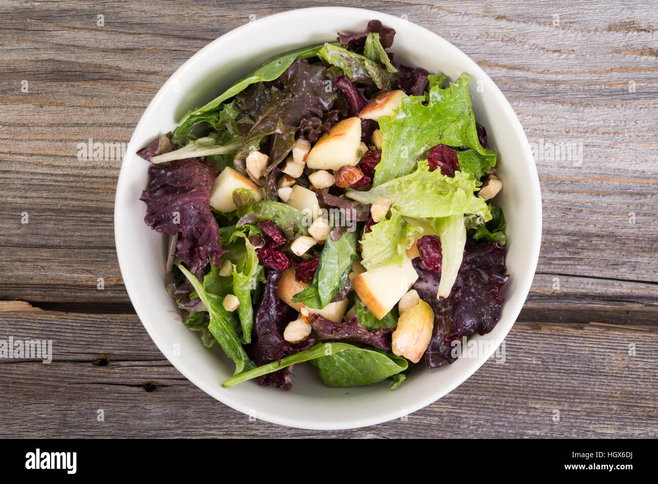 Pommes Canneberges et noix et mélange de salade au fond la planche en bois rustique Banque D'Images