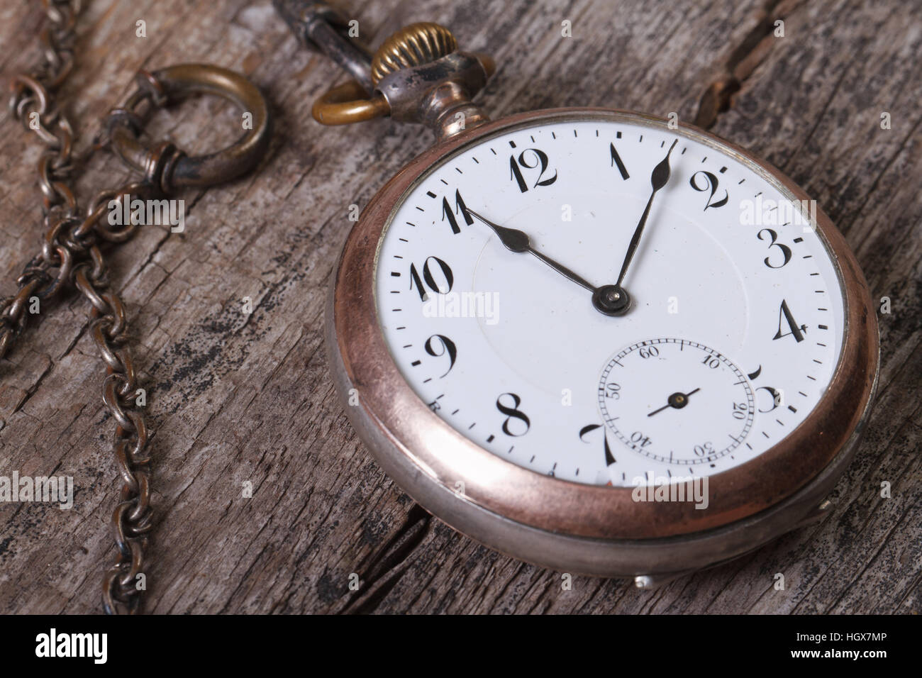 Ancienne montre de poche sur une chaîne sur une vieille table de bois macro Banque D'Images