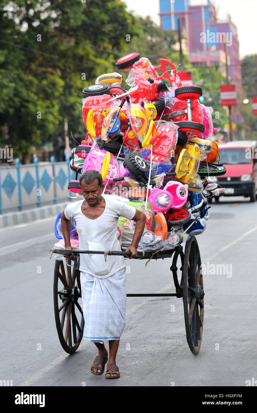 L'Inde Bengale occidental, Calcutta, pousse-pousse tiré la main pleine de jouets en plastique / INDIEN Westbengalen handgezogene Kalkutta, Transportmittel Rikscha mit Plastikspielzeug Banque D'Images