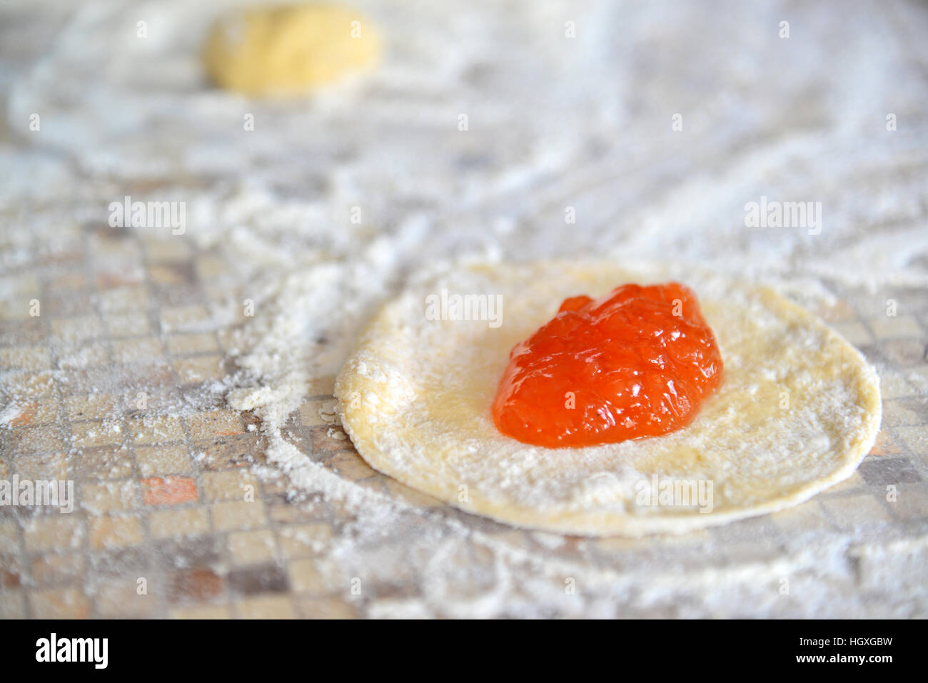 Confiture d'abricots sur la pâte pour la préparation des tartes Banque D'Images