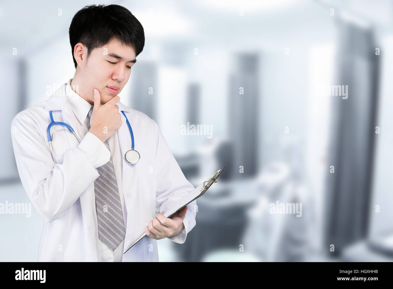 Portrait of Asian doctor holding patient fichier graphique dans un hôpital moderne. Médecin asiatique à la recherche et l'analyse du fichier fichier. Banque D'Images