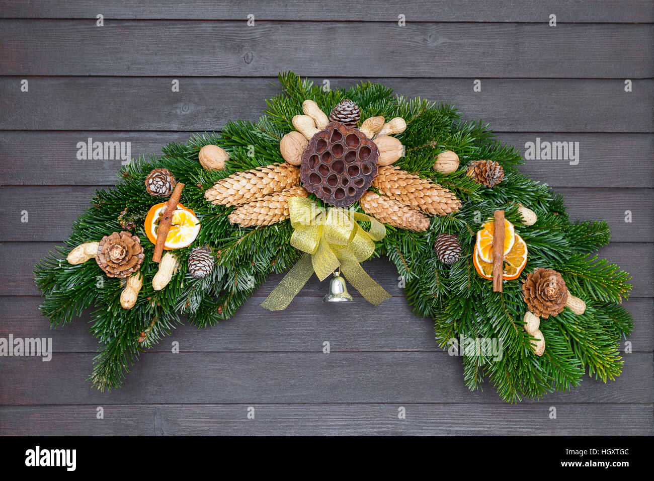 Couronne de Noël et d'hiver avec bow jaune accroché sur la porte en bois foncé avec plaque Banque D'Images
