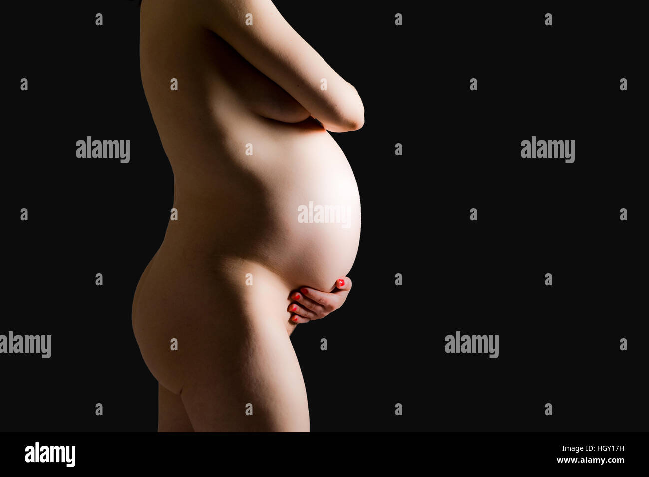 Femme enceinte est holding her belly Banque D'Images