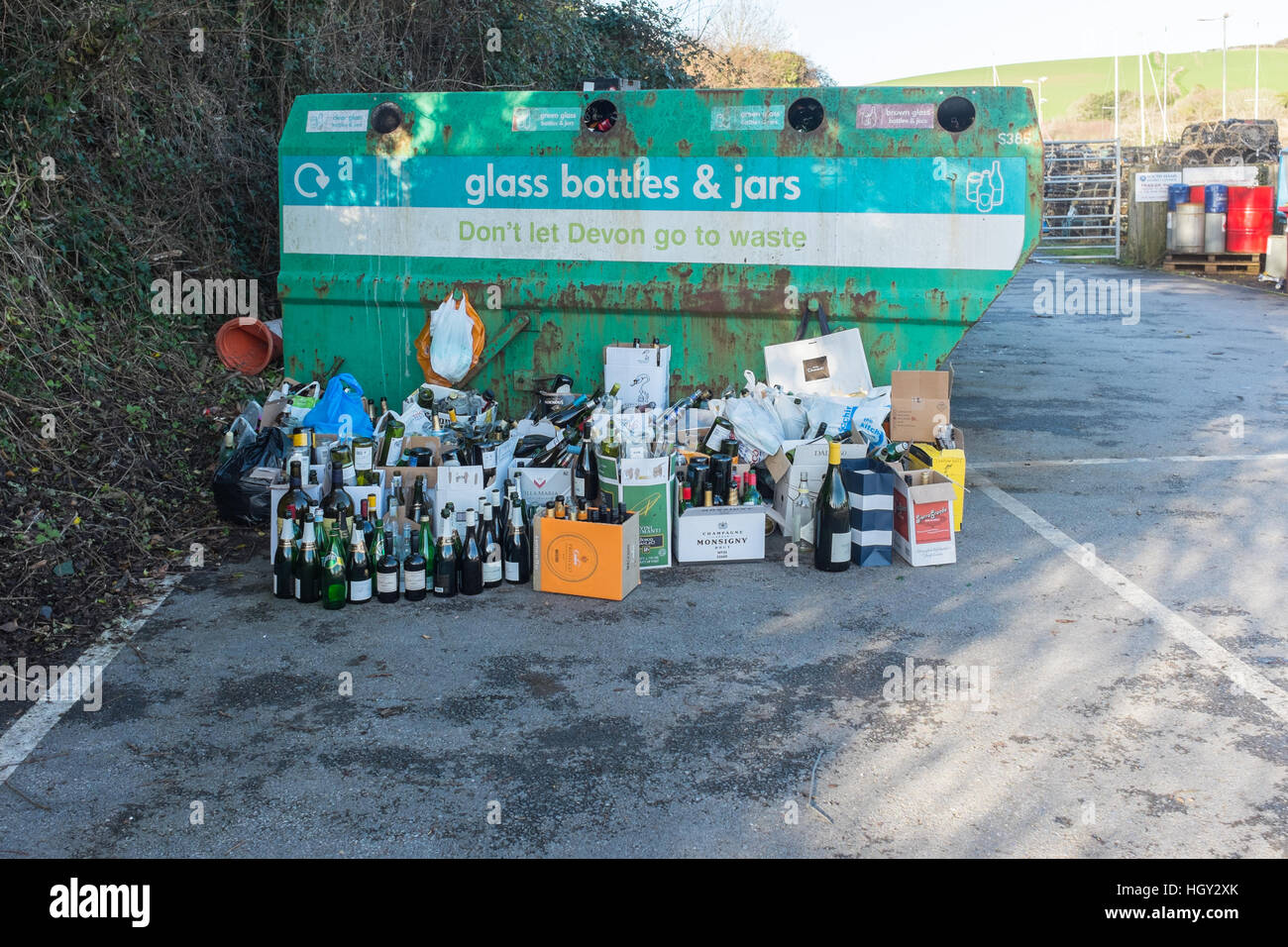 Le flacon en verre bac de recyclage avec des bouteilles entassées à côté Banque D'Images