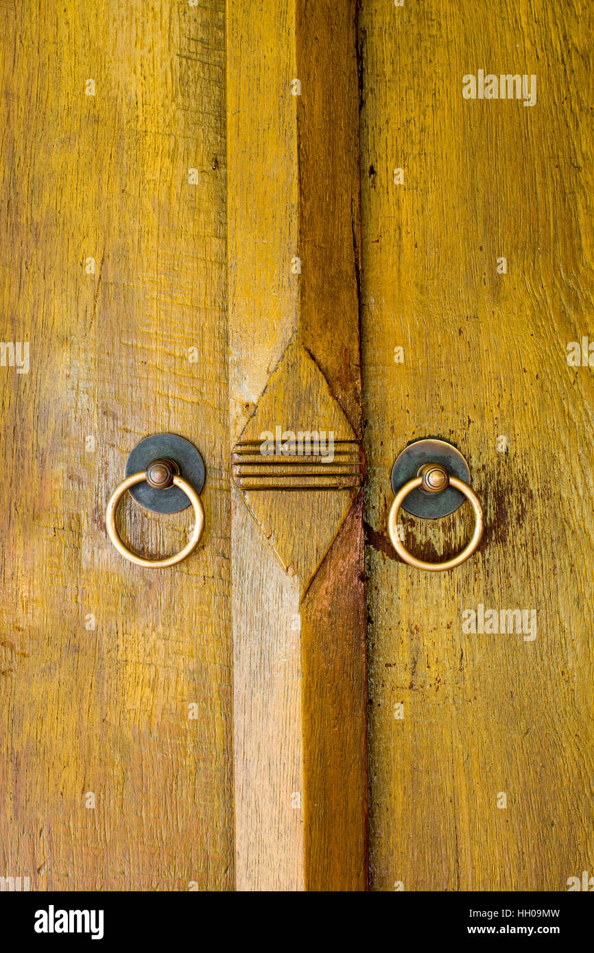 Les panneaux de bois ou de la porte de chambre de style Thaï avec joint laiton doorknockers Banque D'Images