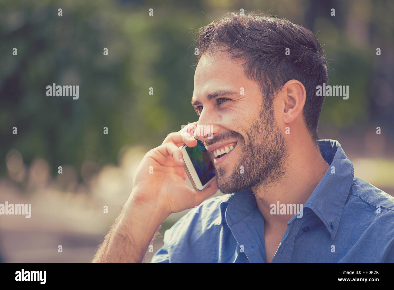 Happy smiling portrait beau jeune homme professionnel en milieu urbain à l'aide de parler sur téléphone intelligent. Businessman holding mobile smartphone Banque D'Images