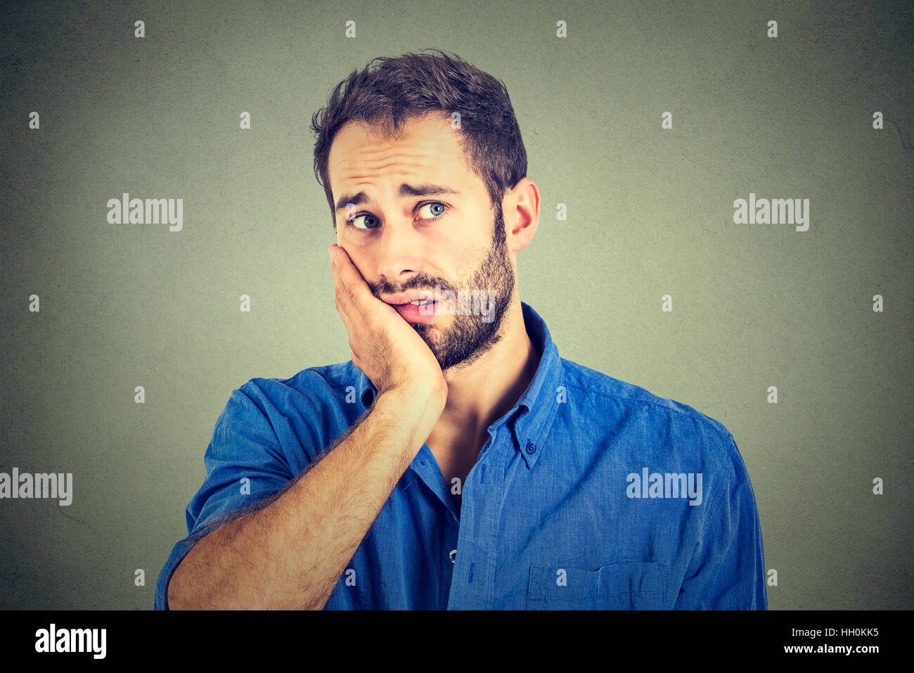 Aucune motivation dans la vie. Triste homme inquiet isolé sur fond de mur gris Banque D'Images