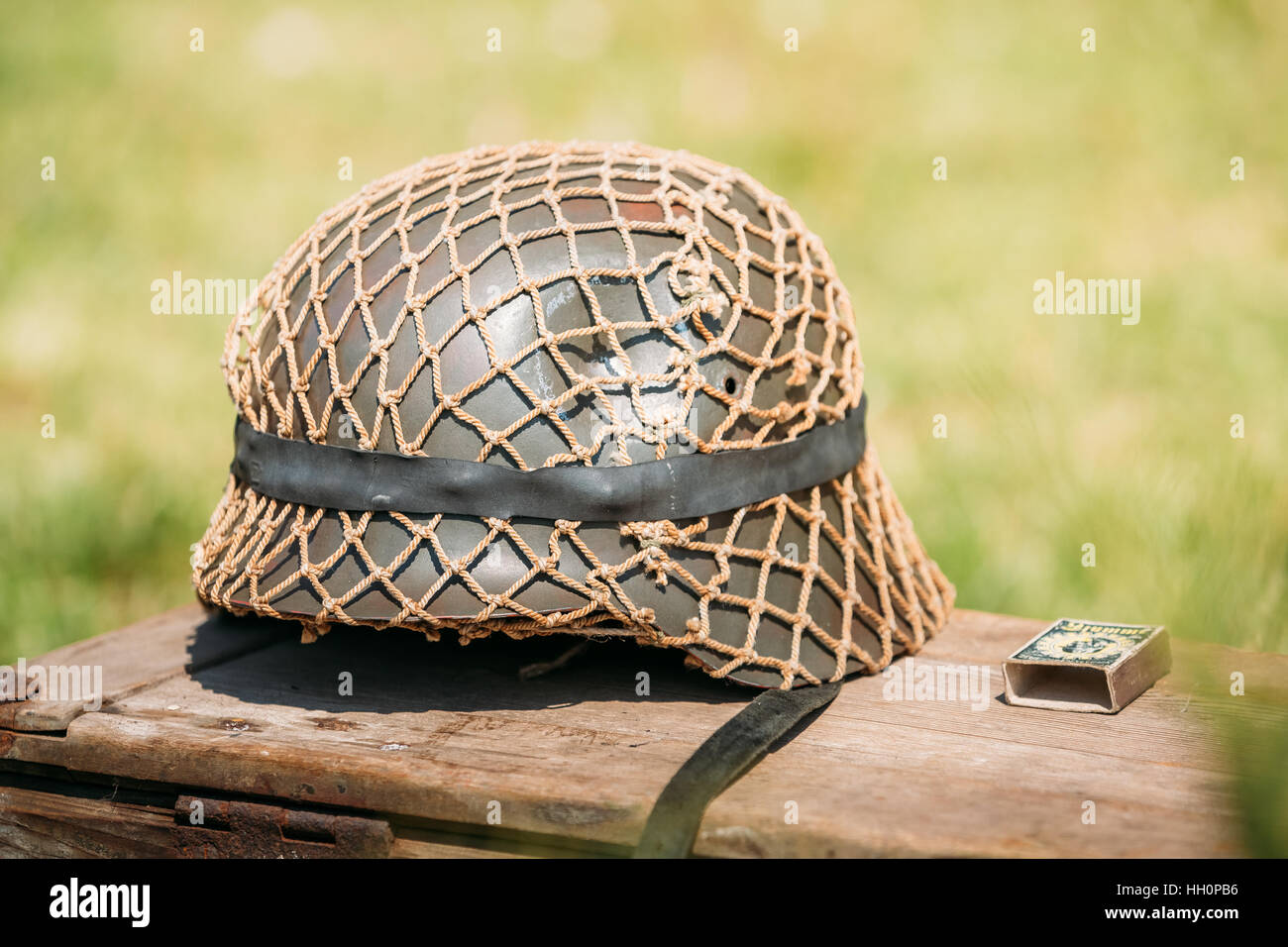 Fermer le casque de métal de soldat d'infanterie de la Wehrmacht, les Forces armées de l'Allemagne nazie durant la Seconde Guerre mondiale, située sur l'ancienne boîte en bois sur le Vert Gr Banque D'Images
