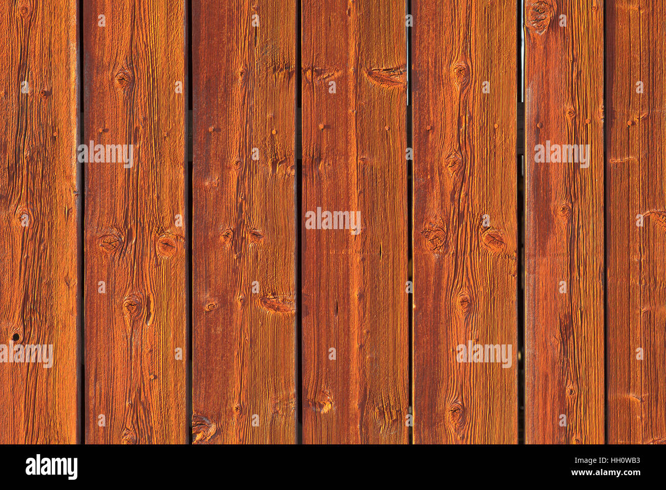 Gros plan sur un mur en bois rouge en plein soleil. Bandes, les conseils peint en rouge. Banque D'Images