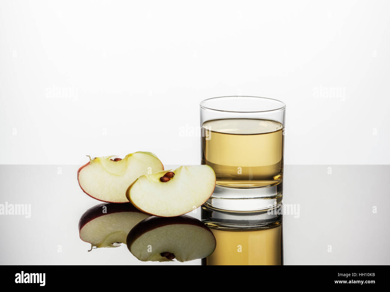 Le jus de pomme et deux tranches de pommes fraîches Banque D'Images