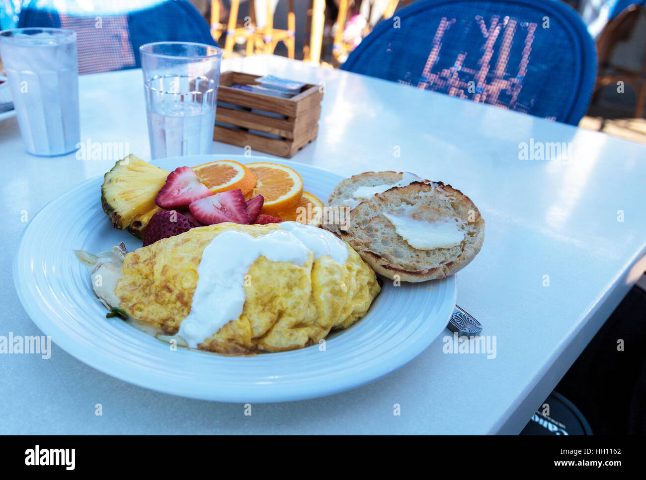 Petit-déjeuner omelette avec du fromage, un muffin anglais avec du beurre et des fruits, y compris l'ananas, les tranches d'orange et les fraises. Banque D'Images