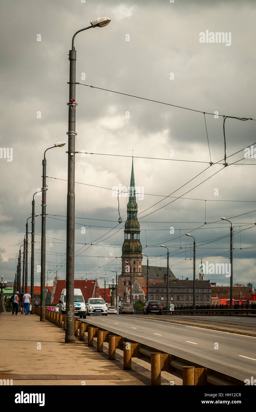 La circulation automobile sur le pont Akmens à Riga. Église Saint Pierre sur l'arrière-plan sous ciel couvert Banque D'Images