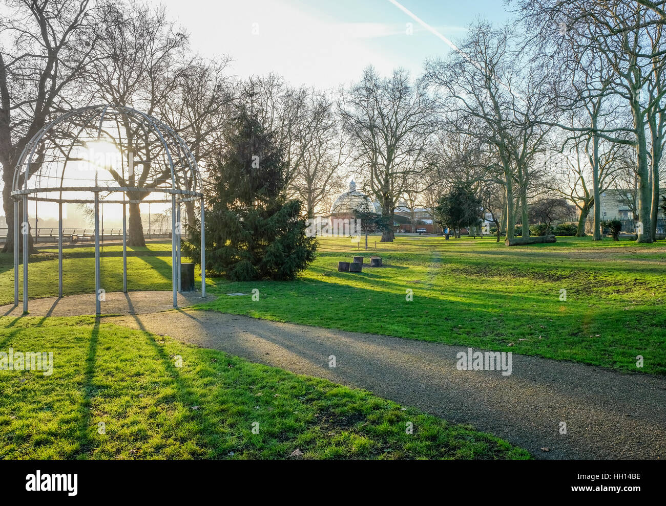 Island Gardens Park sur l'Isle of Dogs. Pris par un beau jour d'hiver avec un ciel bleu et le soleil brille à travers l'arbor. Banque D'Images