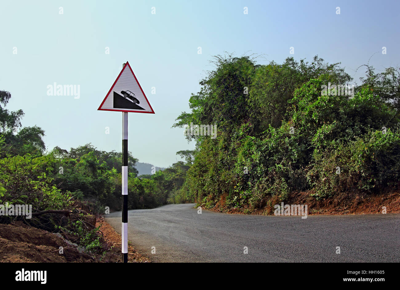 La signalisation routière pour prévenir les automobilistes d'être prudents lors de la forte pente de l'avant dans une autoroute à travers la forêt en zone de collines Banque D'Images