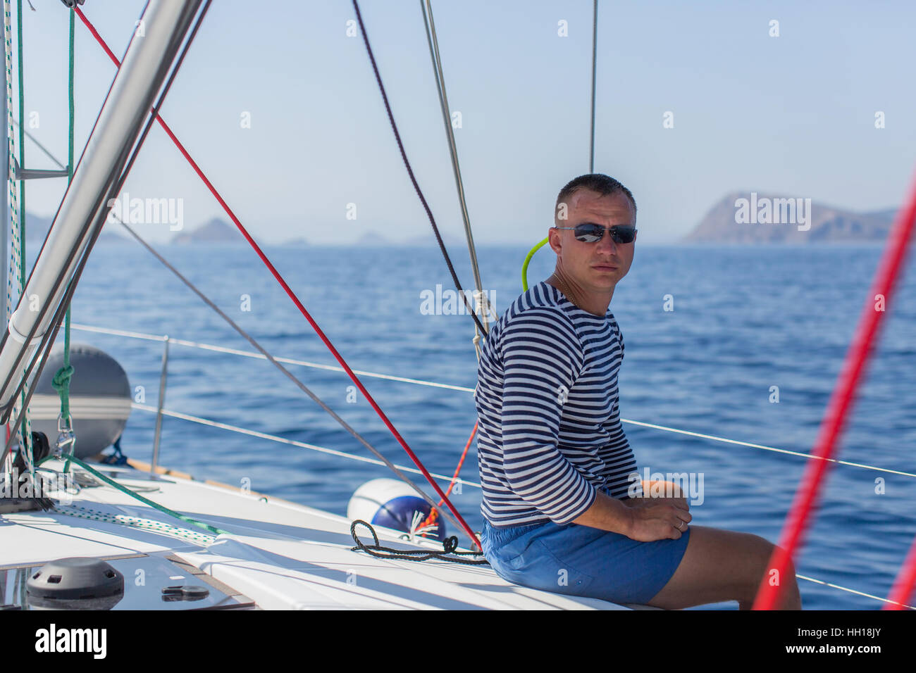 Jeune skipper sur son bateau à voile. Banque D'Images