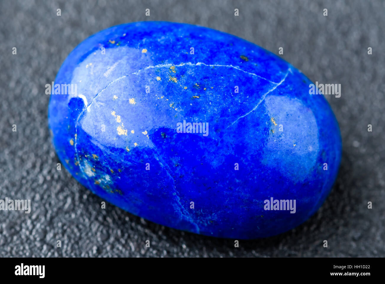 En valeur le bleu lapis lazuli cabochon ovale avec de petites taches d'or. Banque D'Images