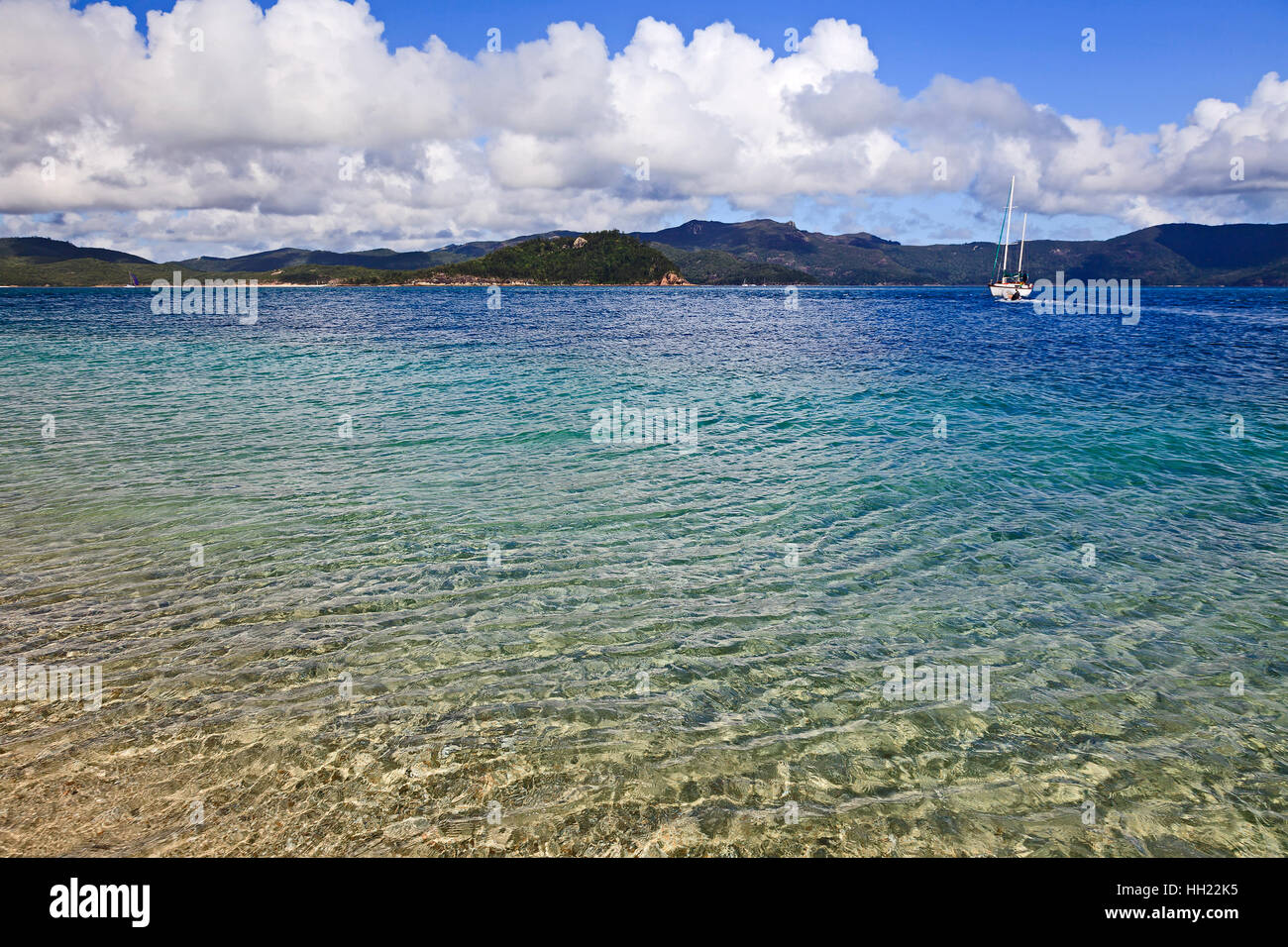 Nettoyer l'eau transparente à Coral Island lagoon de whitesunday islands. Blanc solitaire yachs ancrée au large des côtes en mer de corail de grande bareer récifs d'Aus Banque D'Images