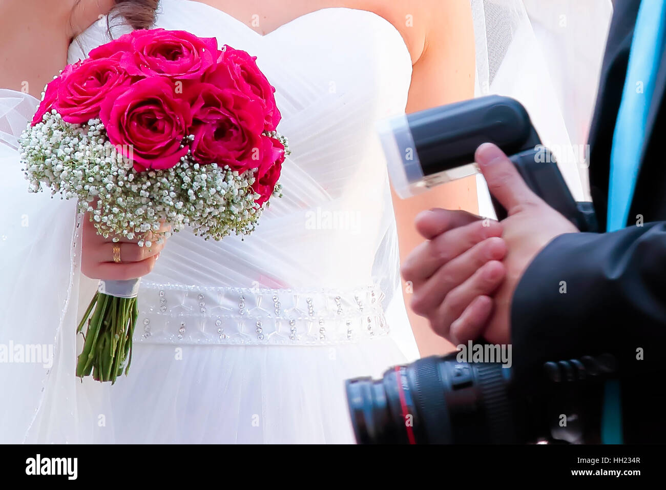 L'avant-plan des mains d'une bride holding bouquet et l'appareil photo du photographe Banque D'Images