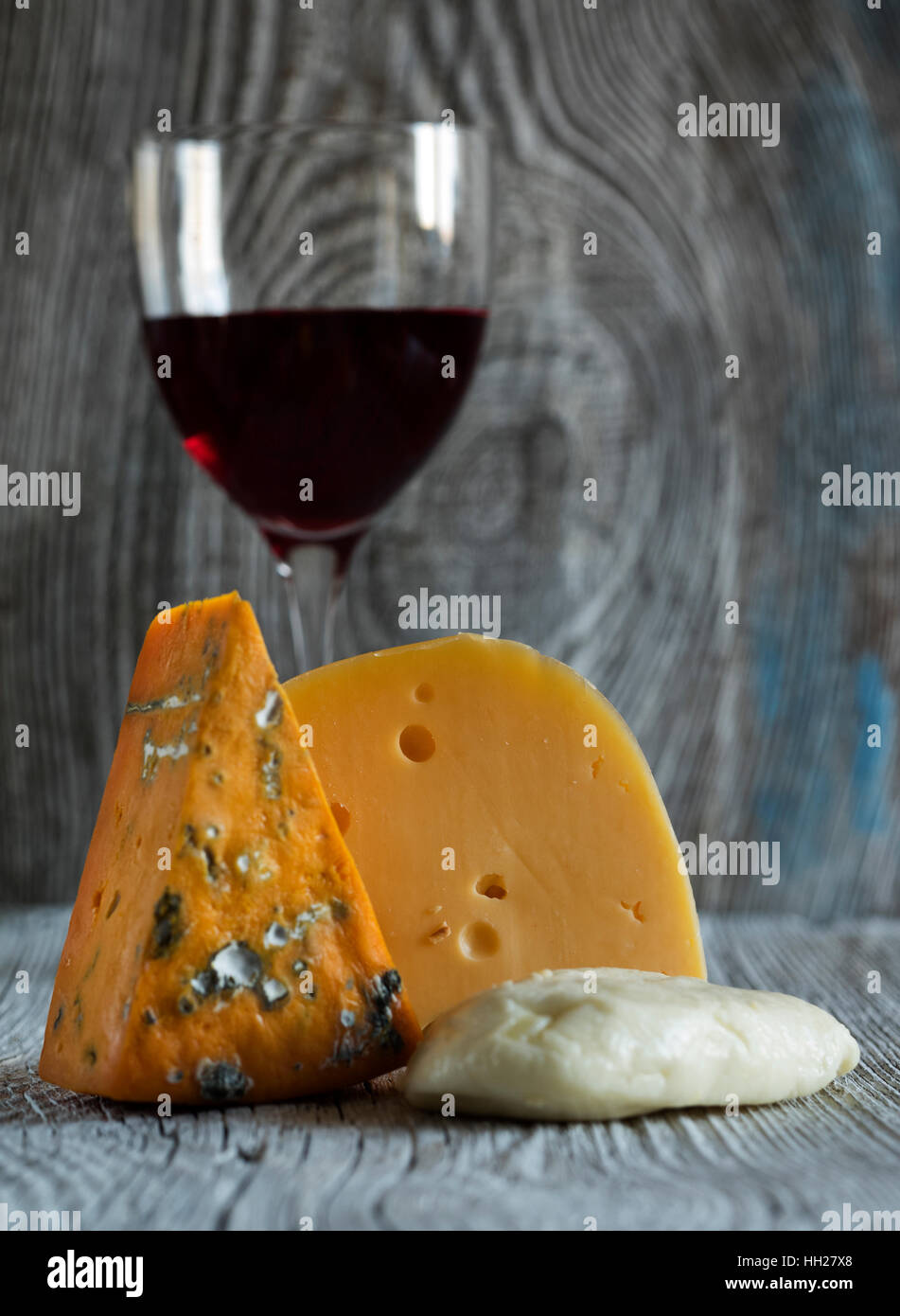 Des morceaux de fromage (Mozzarella, roquefort, Maasdam) et du vin à l'ancienne en bois fond d'altération Banque D'Images