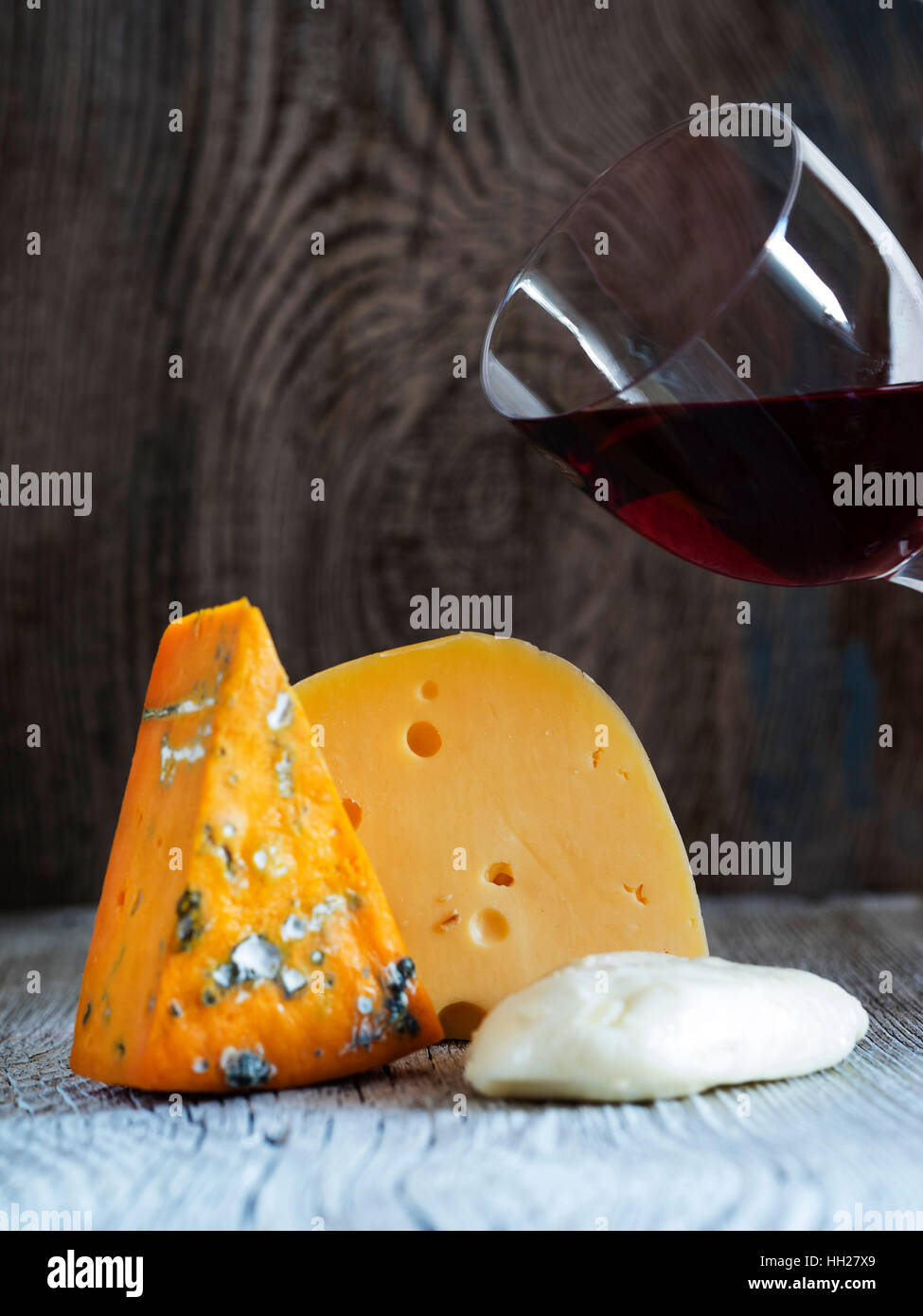 Des morceaux de fromage (Mozzarella, roquefort, Maasdam) et du vin à l'ancienne en bois fond d'altération Banque D'Images