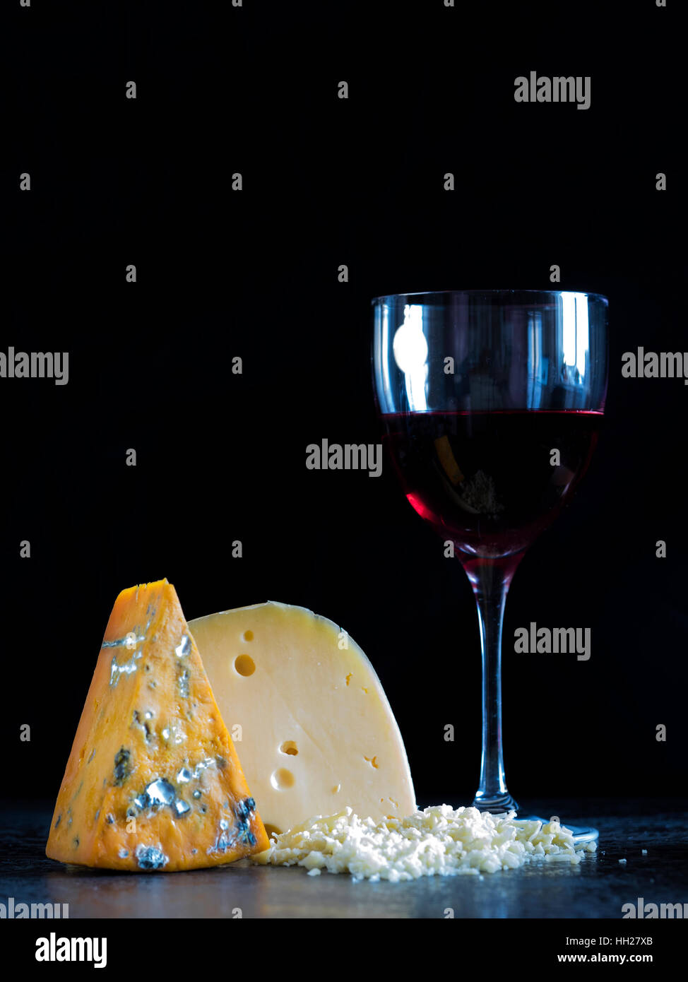 Des morceaux de fromage (roquefort, Maasdam) et le vin sur la table en pierre Banque D'Images