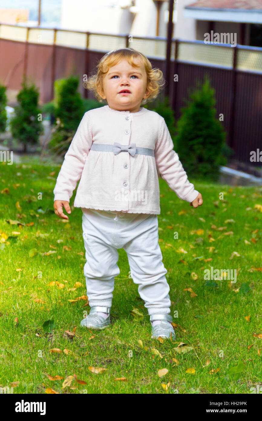 Petite fille avec des cheveux bouclés on Green grass Banque D'Images