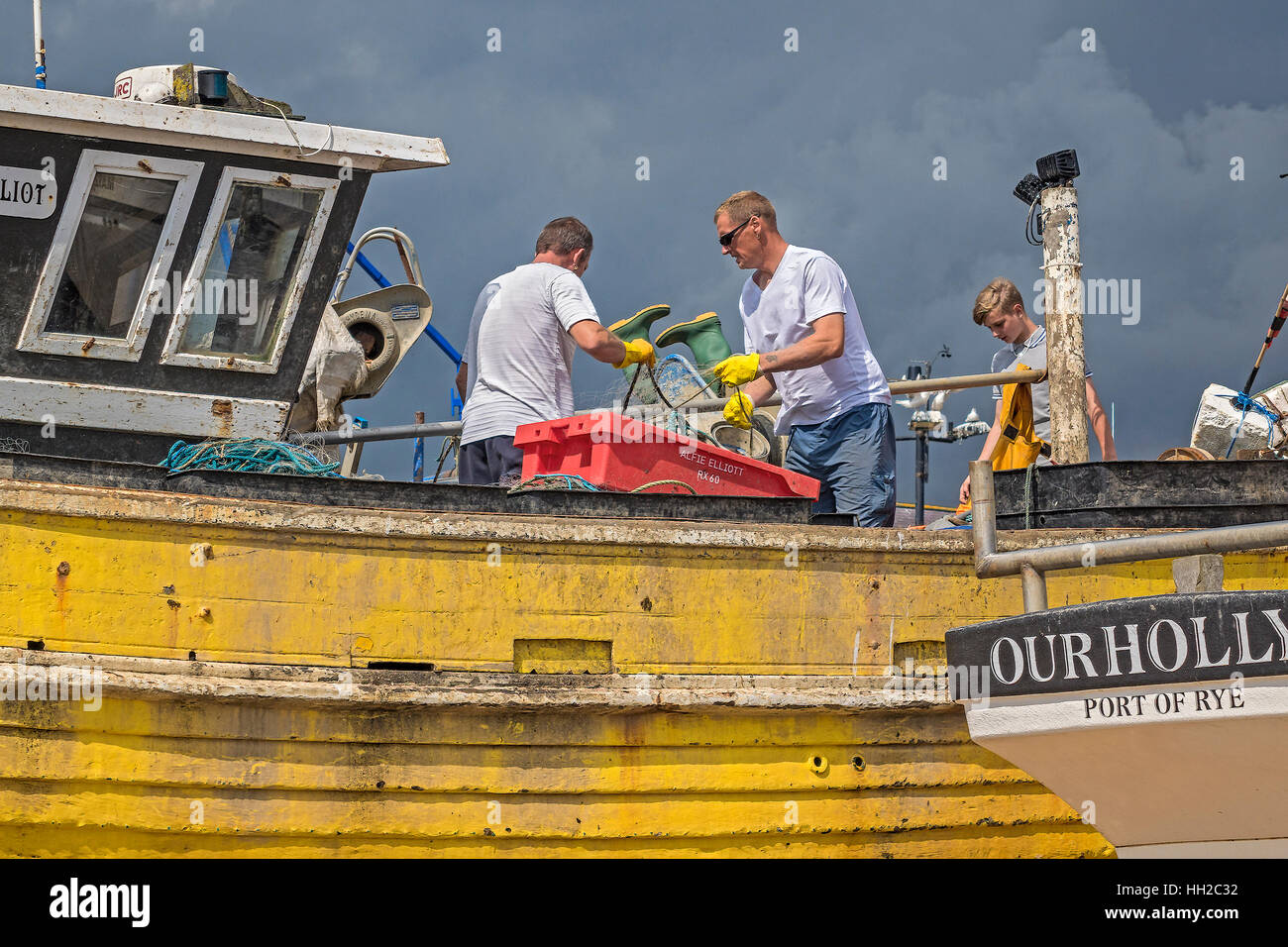 Nettoyer les bateaux de pêche sur la plage Hastings UK Banque D'Images