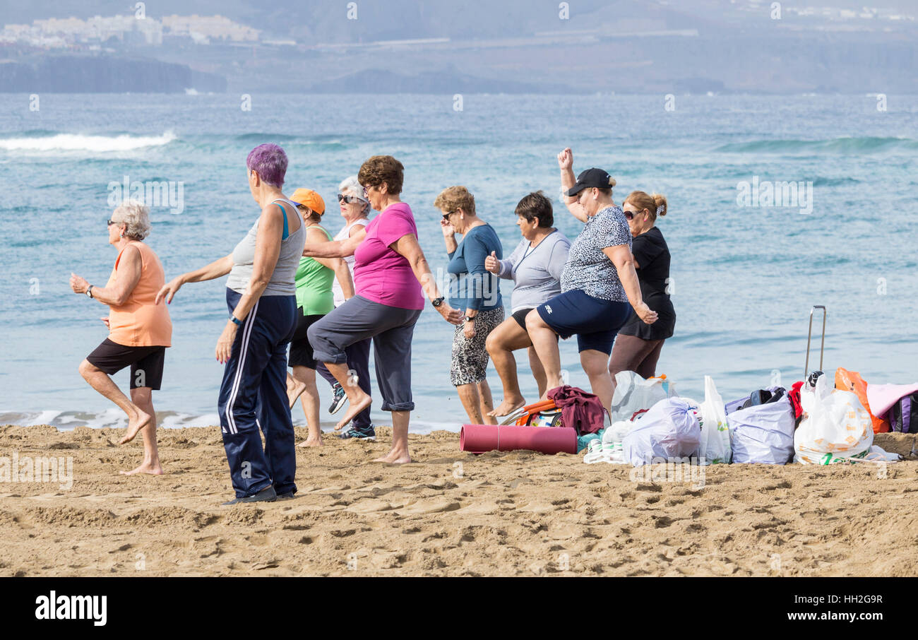 Un groupe de personnes âgées les femmes locales à leur exercice quotidien classe sur la plage de Las Canteras à Las Palmas, Gran Canaria, Îles Canaries, Espagne. Banque D'Images