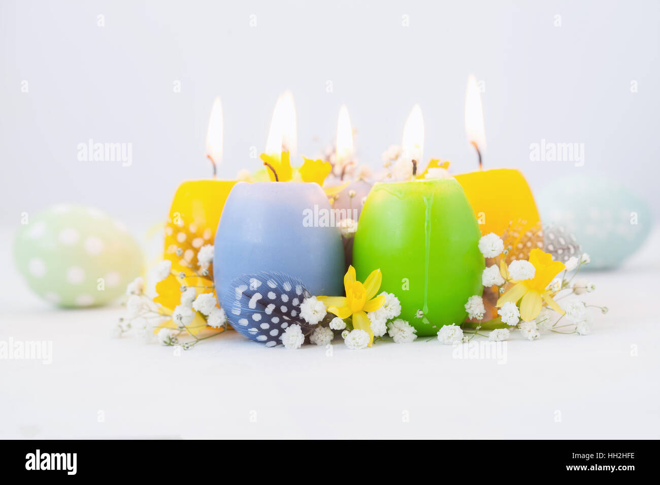 Oeufs de Pâques colorés des bougies et des fleurs Banque D'Images