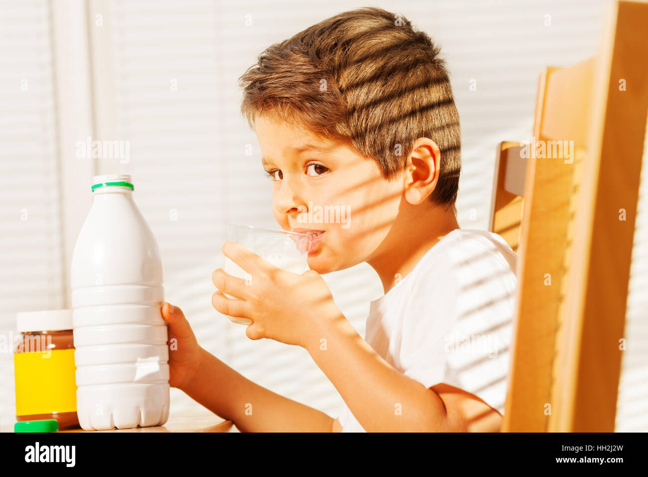 Petit garçon buvant du lait au petit-déjeuner Banque D'Images