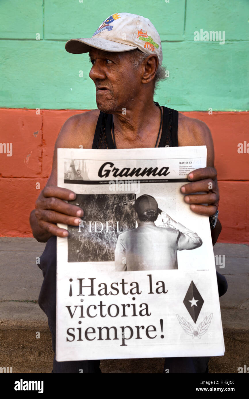 Homme avec journal Granma à Trinidad, Cuba, après la mort de Fidel Castro Banque D'Images