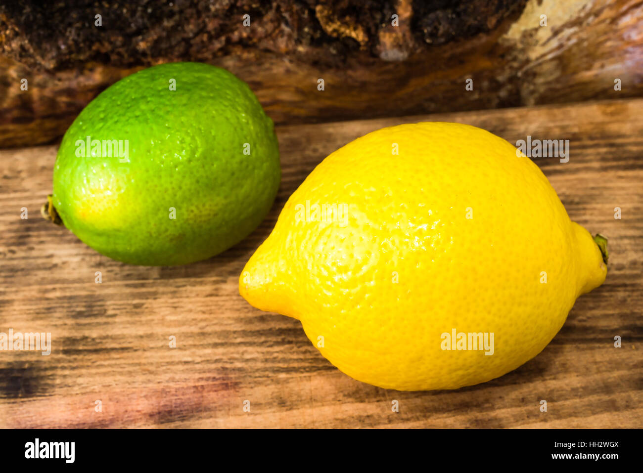 Forte et aigre citron et chaux sur planche à découper en bois. Banque D'Images
