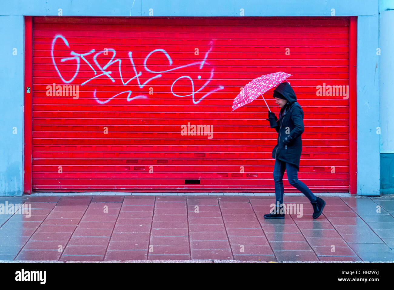 Brighton, UK. 14 janvier, 2017. Un piéton marche dans la pluie en bas de la principale rue commerçante à Brighton, passé jusqu'à bord d'unités commerciales Crédit : Andrew Hasson/Alamy Live News Banque D'Images