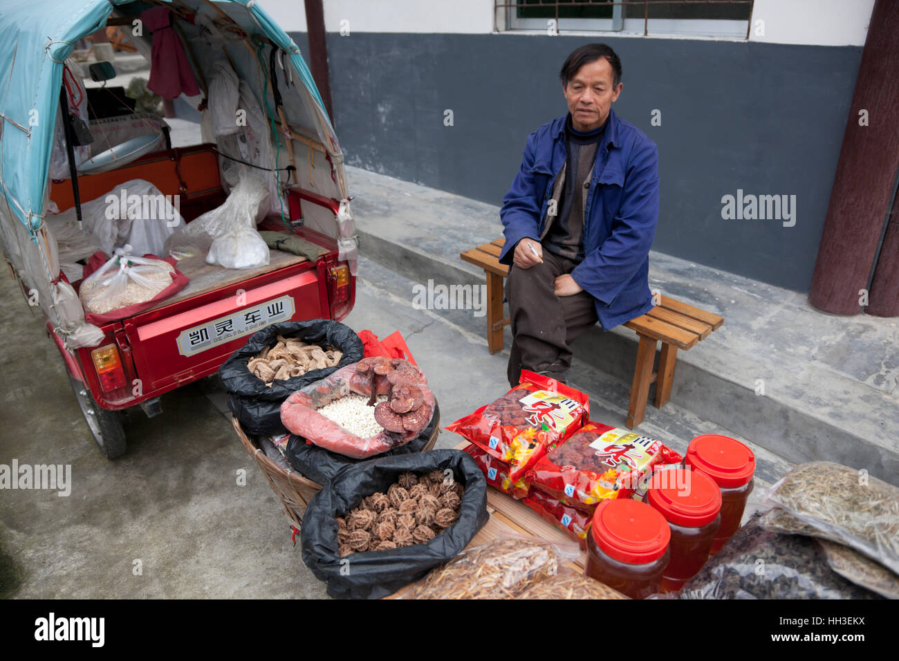 Un colporteur avec son ware d'aliments sauvages et de miel à l'extérieur de la réserve naturelle de Tangjiahe dans le Sichuan. Banque D'Images