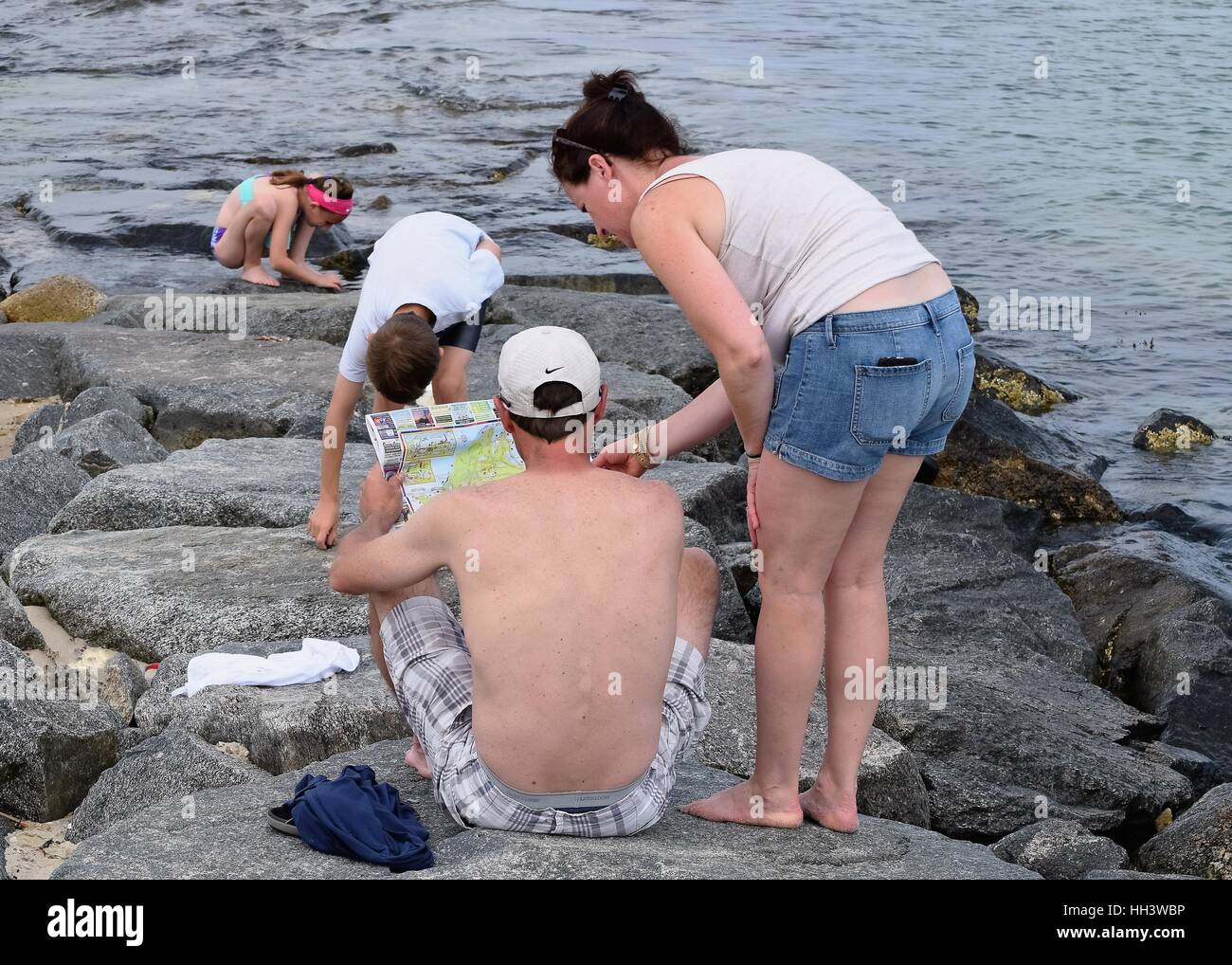 Jeune famille en regardant une carte de l'île de Martha's Vineyard, assis sur et explorer une jetée océan local Banque D'Images