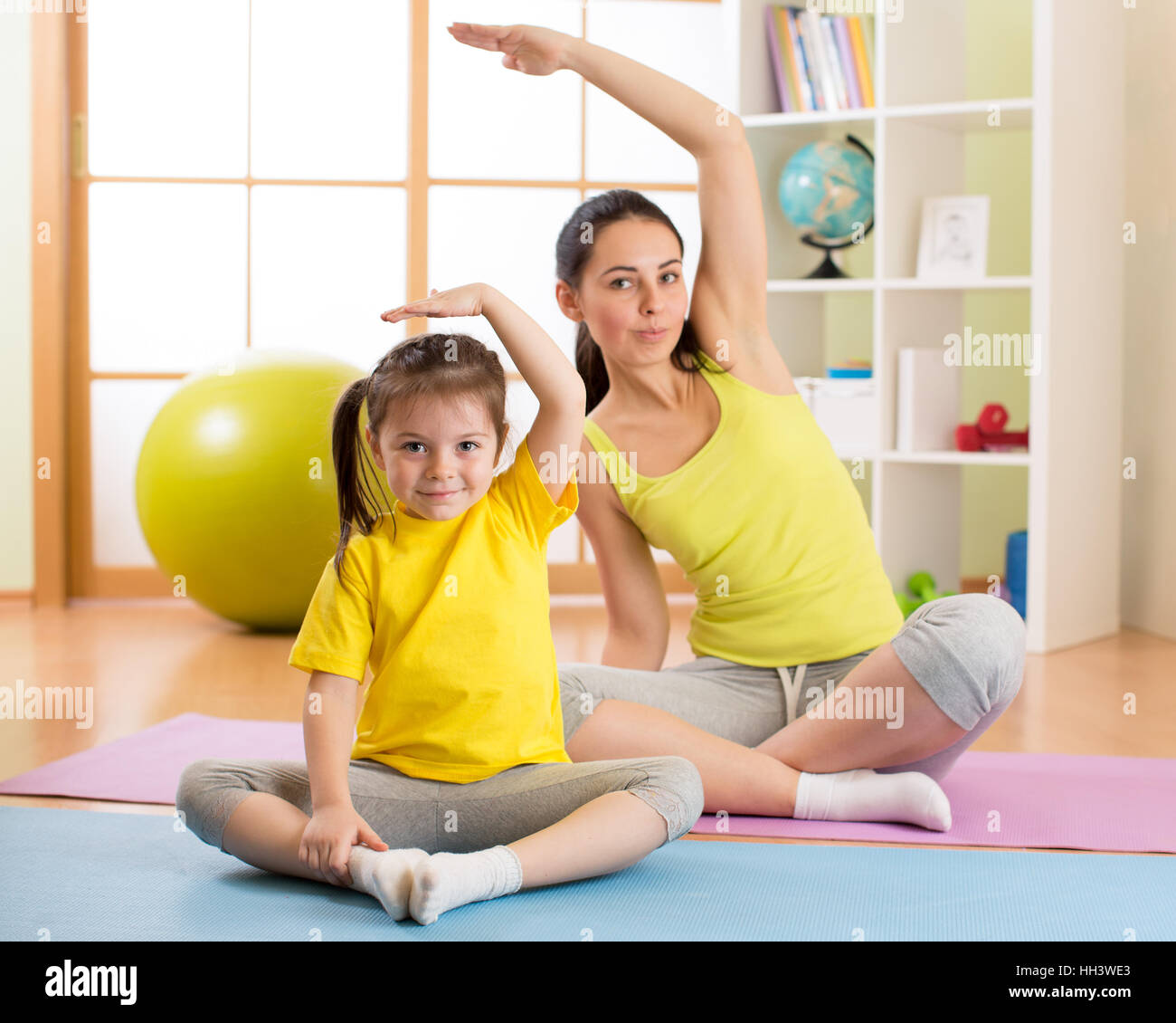 Portrait de jeune fille et sa mère faire de la gymnastique à la maison d'exercice Banque D'Images