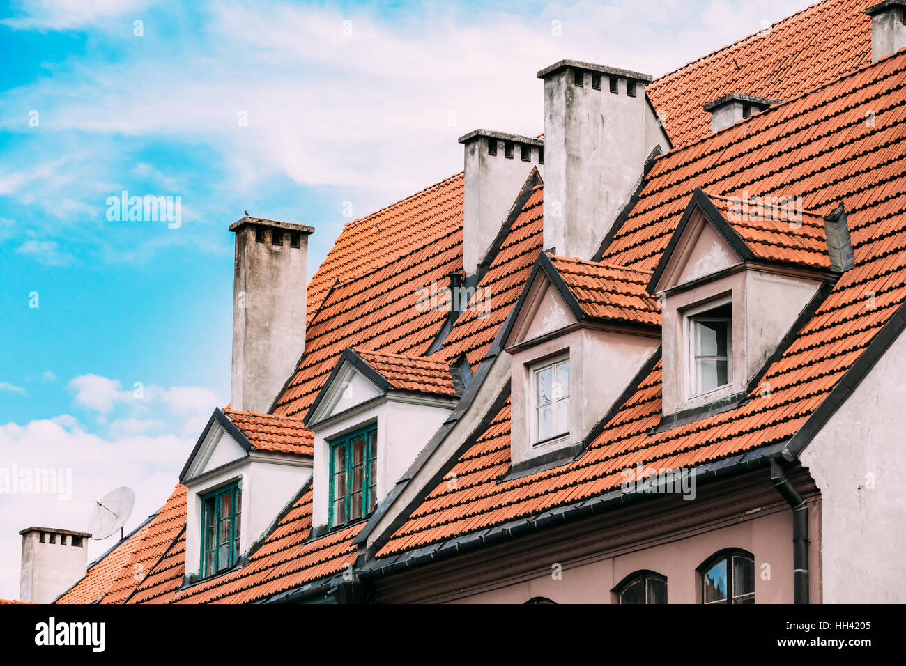 Riga, Lettonie. L'avis de tuile rouge avec toit en mansarde Gable quatre lucarnes sur la façade de l'ancien bâtiment sous ciel bleu. Banque D'Images