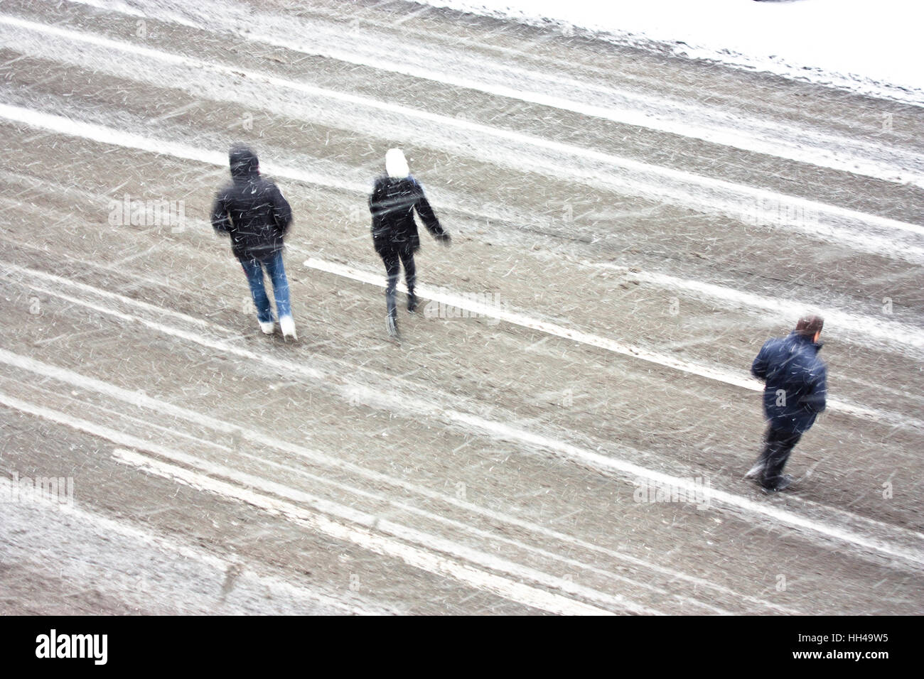 Trois personnes qui traversent le boulevard vide pendant la tempête, high angle view Banque D'Images