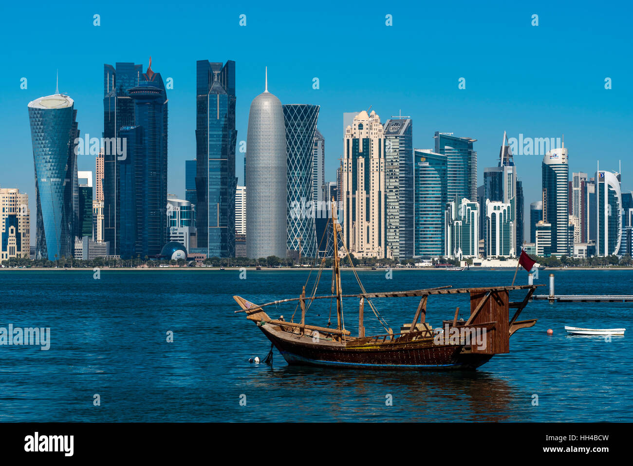 Bateau à voile traditionnel dhow avec le domaine financier derrière l'horizon, Doha, Qatar Banque D'Images