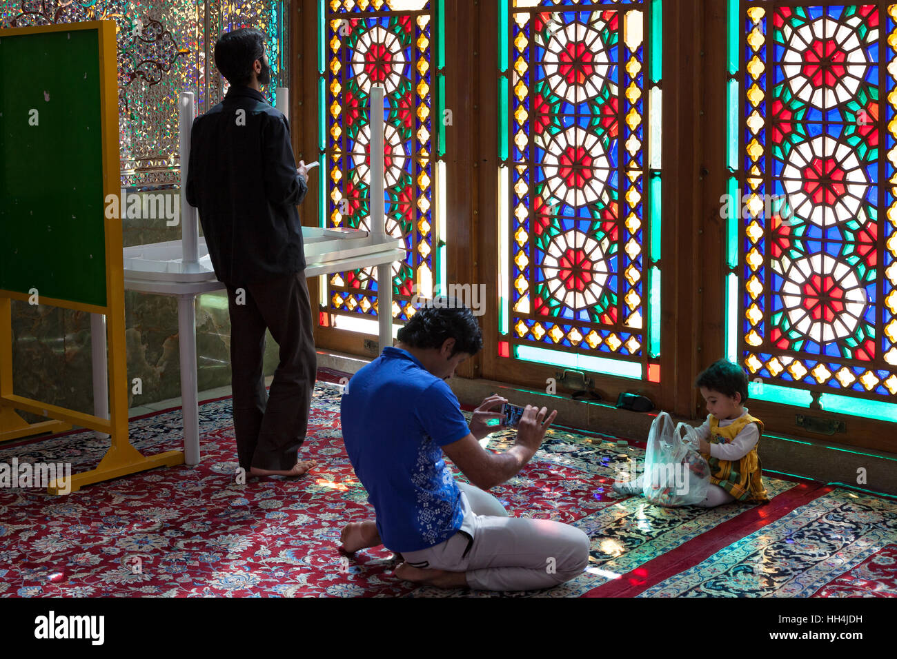 Shiraz, Iran - 20 octobre 2015 : Les gens en face de vitraux colorés à l'intérieur de Shah Cheragh Shrine Banque D'Images