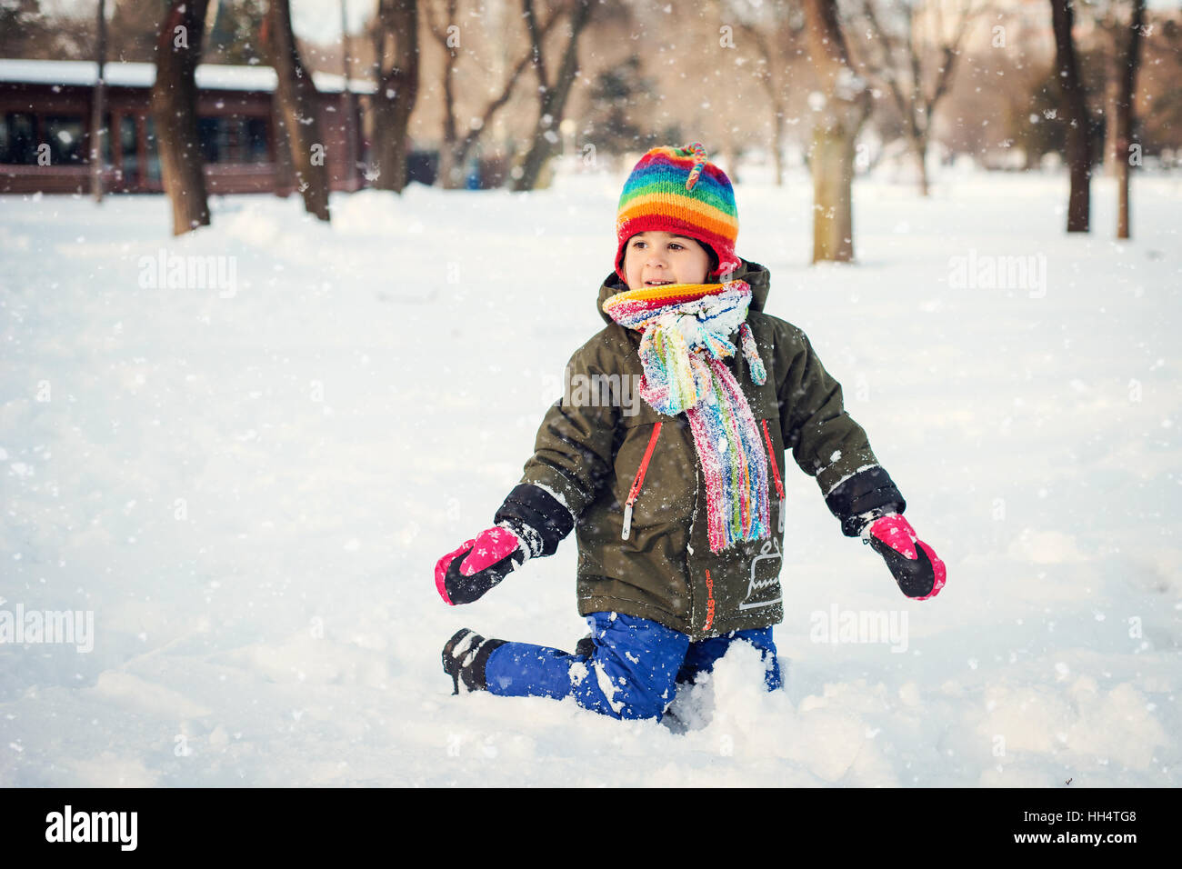 Enfant joue avec la neige durant l'hiver Banque D'Images