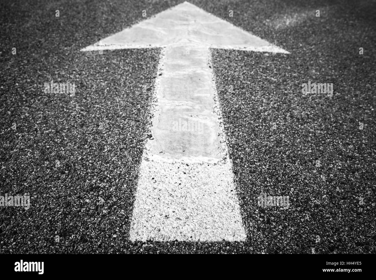 Flèche blanche s'éteint sur l'asphalte de la route, sens de la Banque D'Images