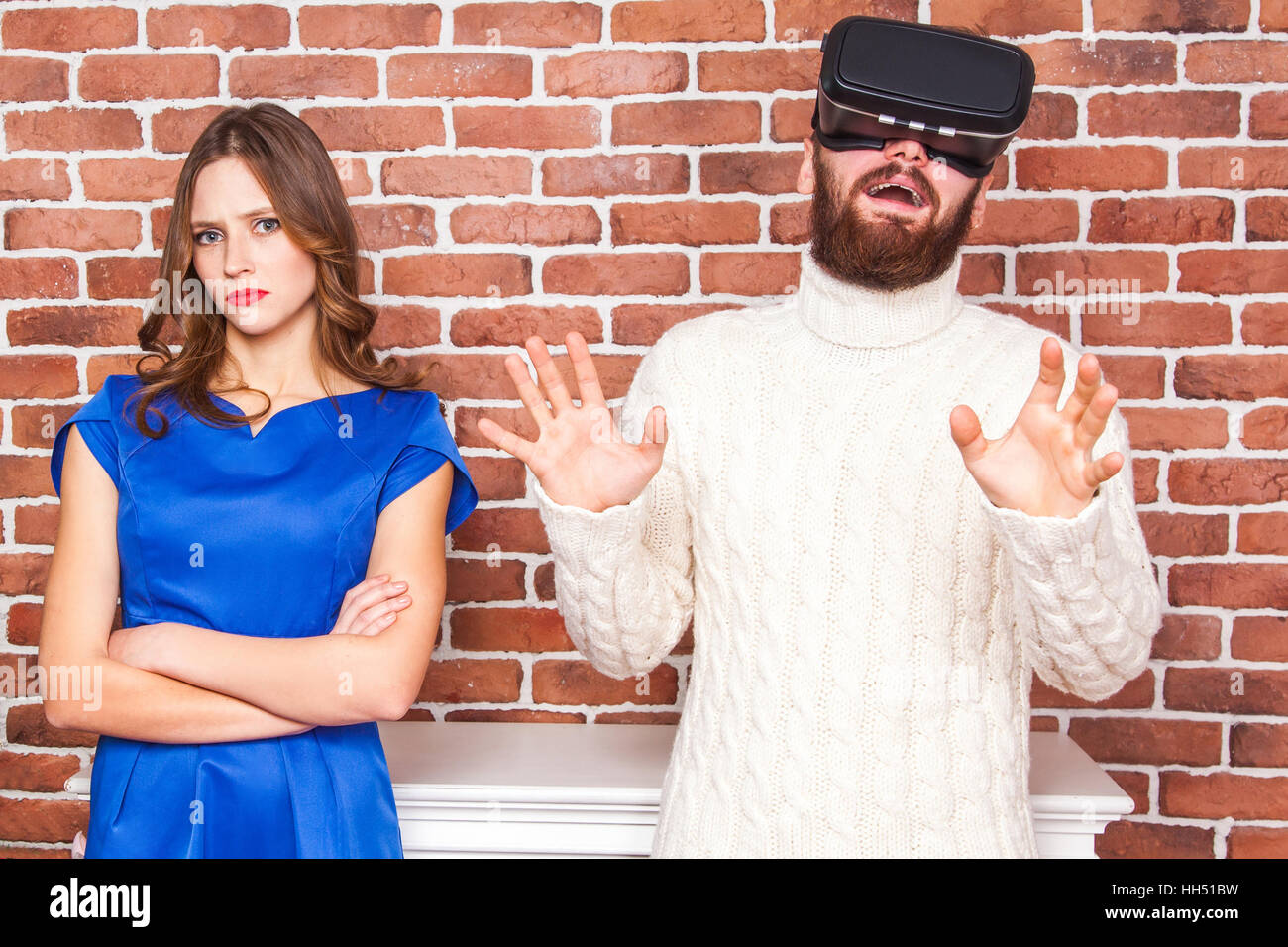 La technologie VR et de conflit entre couple. l'homme à l'aide de casque vr et son épouse est en colère. Banque D'Images