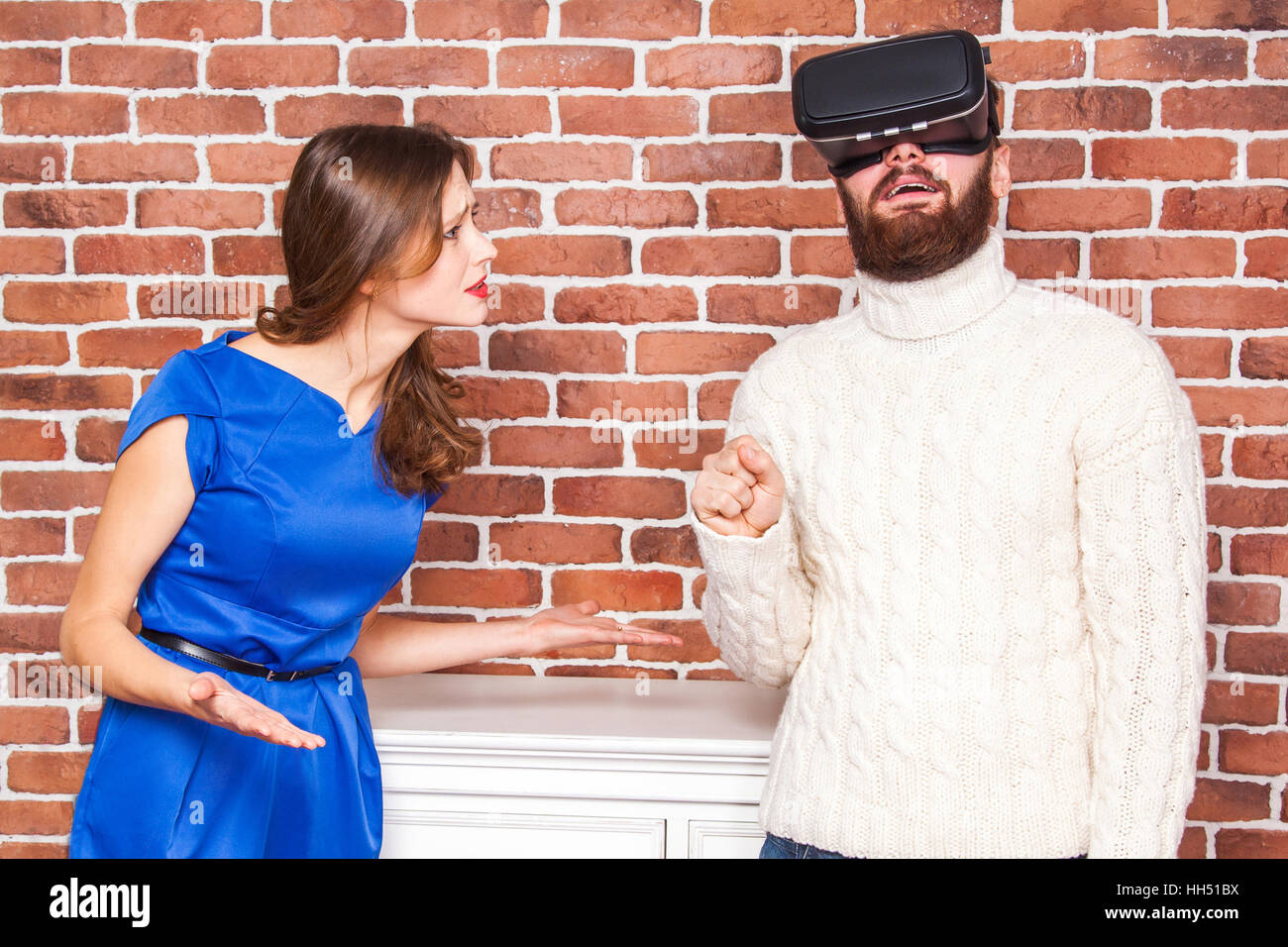 La technologie VR et de conflit entre couple. l'homme à l'aide de casque vr et son épouse est en colère. Banque D'Images