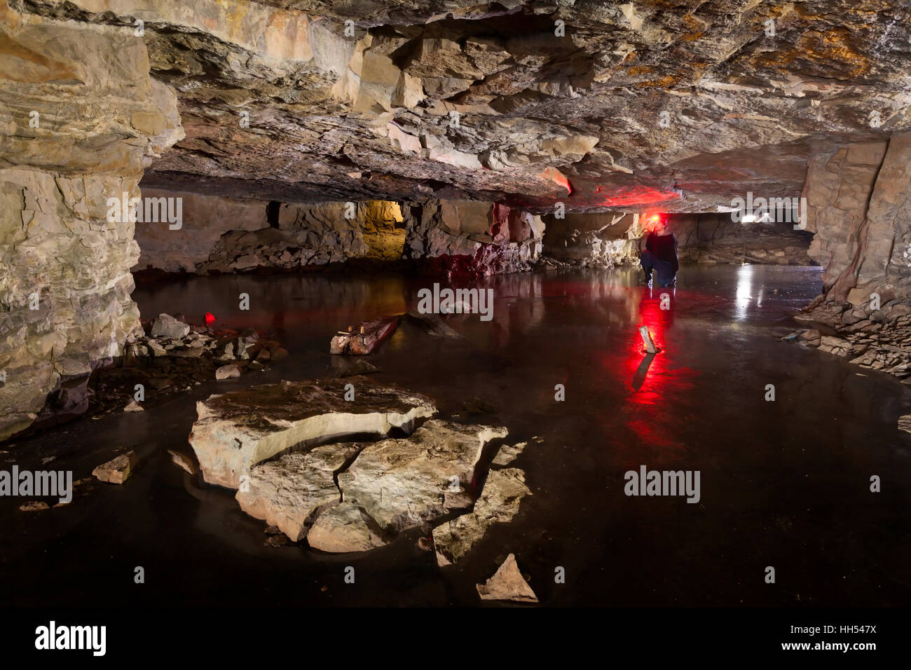 Un homme s'accroupit dans une mine souterraine, qui était autrefois utilisée pour extraire le calcaire blanc. Le Canada. Banque D'Images