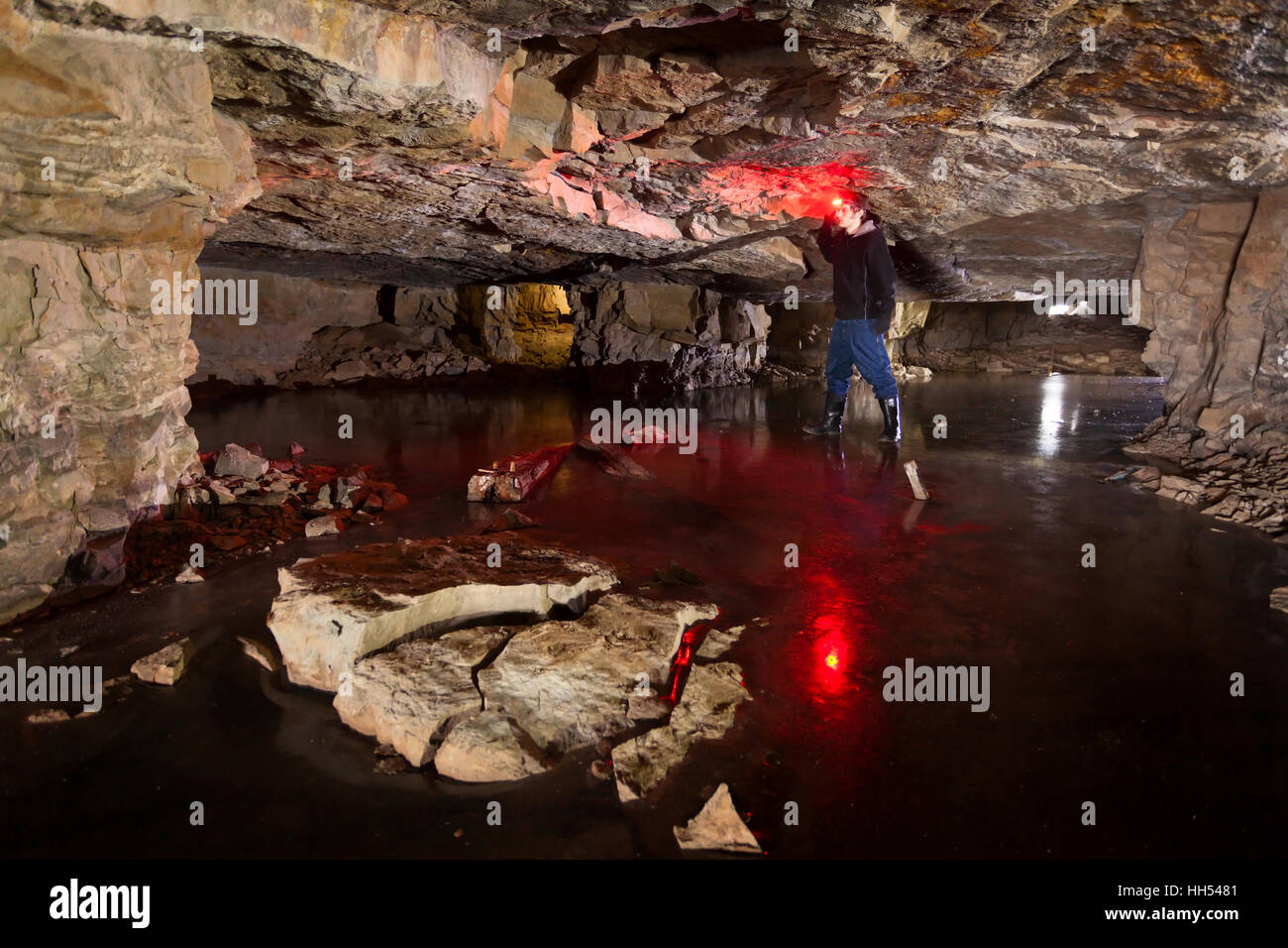 Un homme debout et toucher le plafond dans une mine souterraine, qui était autrefois utilisée pour extraire le calcaire blanc. Le Canada. Banque D'Images