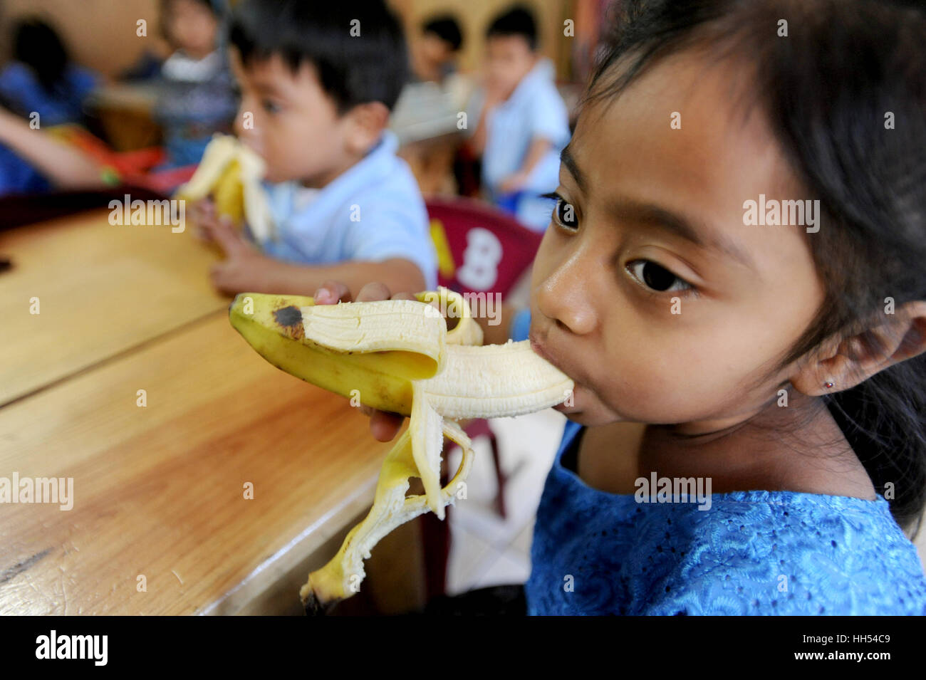 Les enfants autochtones mayas banane manger à l'âge préscolaire à San Jorge la Laguna, Solola ministère au Guatemala. Banque D'Images