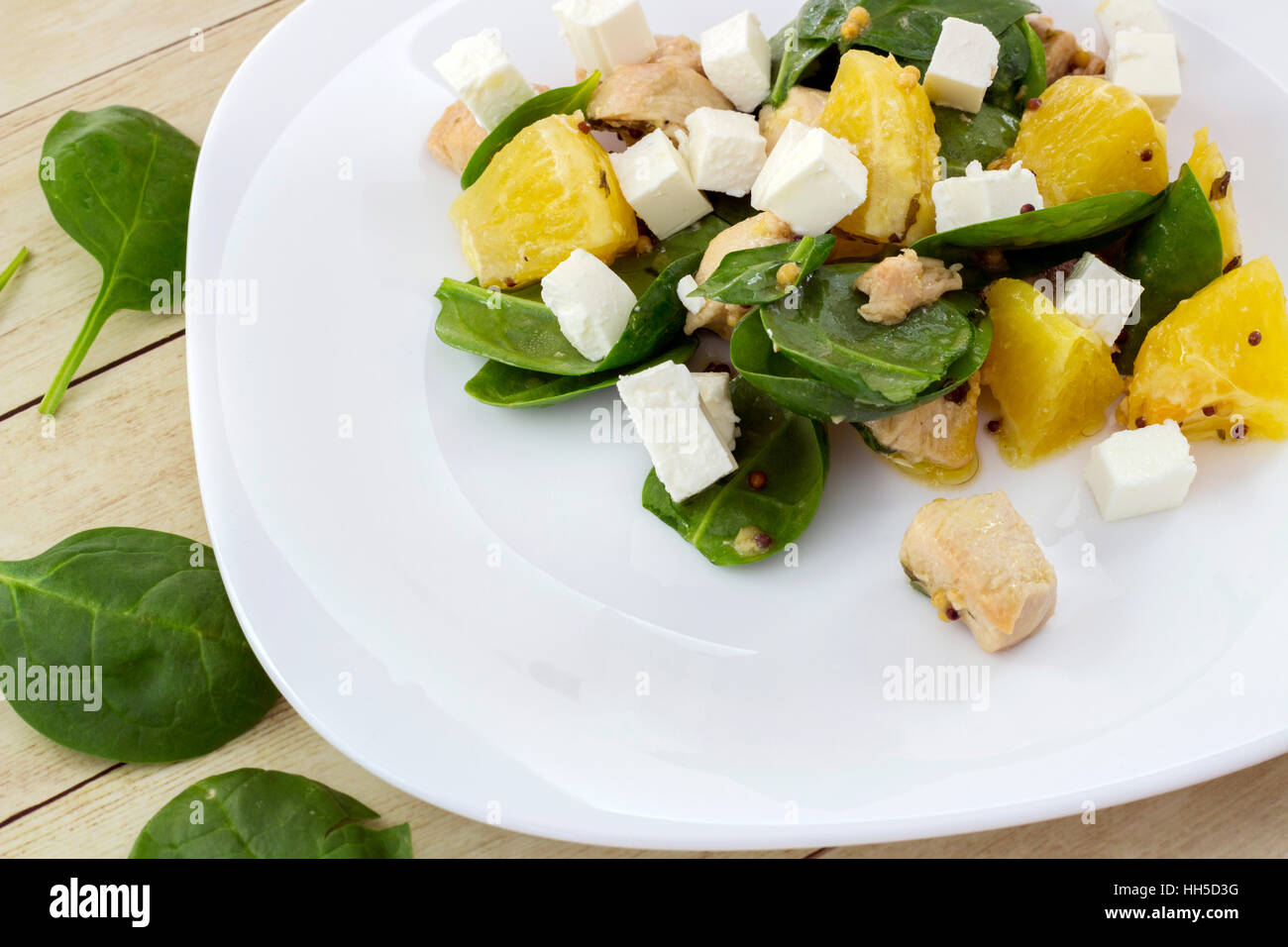 Garni de salade Feta couper des épinards, poulet et orange on white plate Banque D'Images