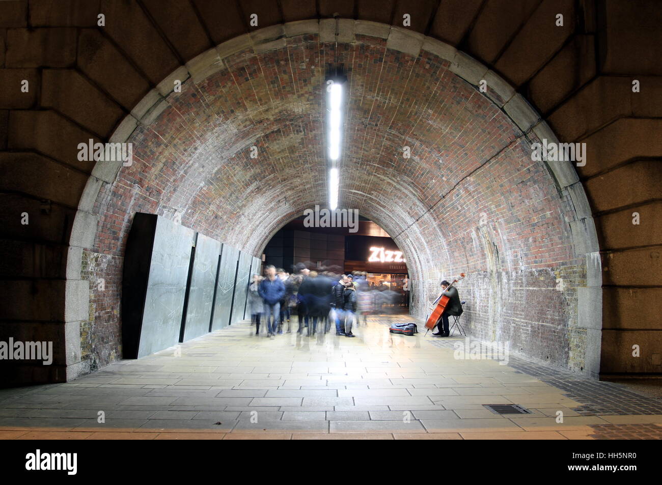 Une photographie d'un musicien ambulant jouant dans une arche sous Southwark Bridge. Banque D'Images